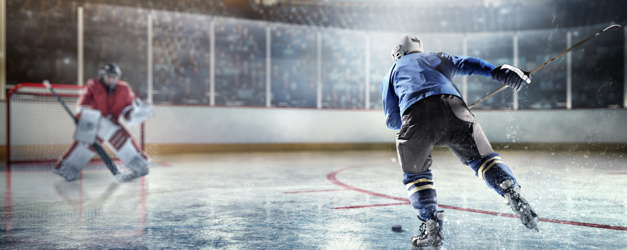 Hockey player taking a slapshot on a goalie