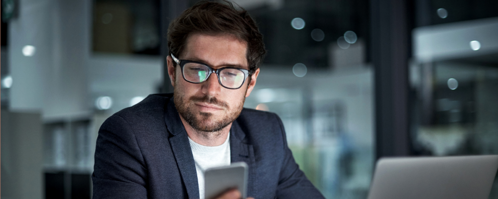 Man looking at his phone while in the office