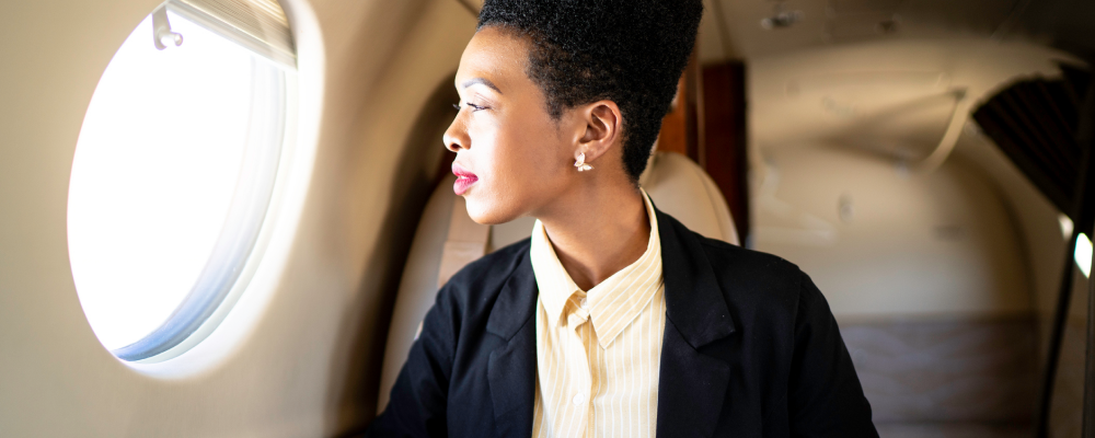 Woman looking out the window of a private jet