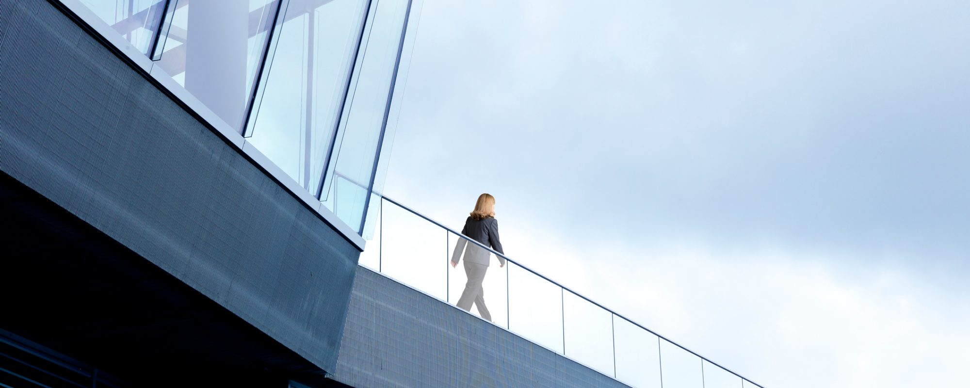 Businesswoman walking along an office balcony walkway