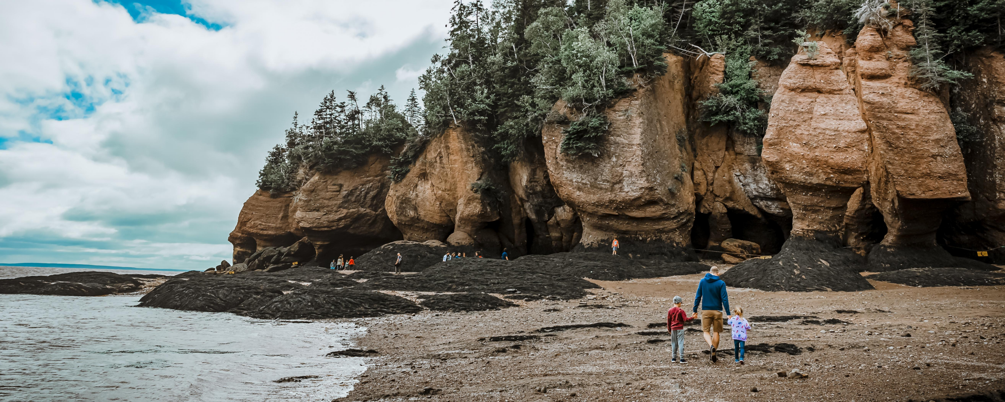 Family walking along rocky beach