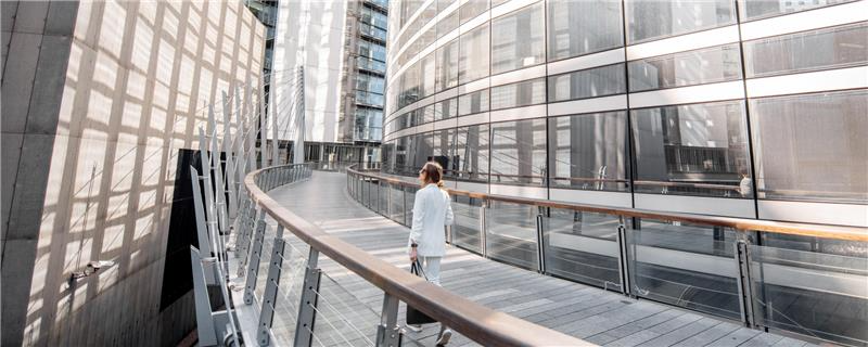 A woman walking in front of office building.