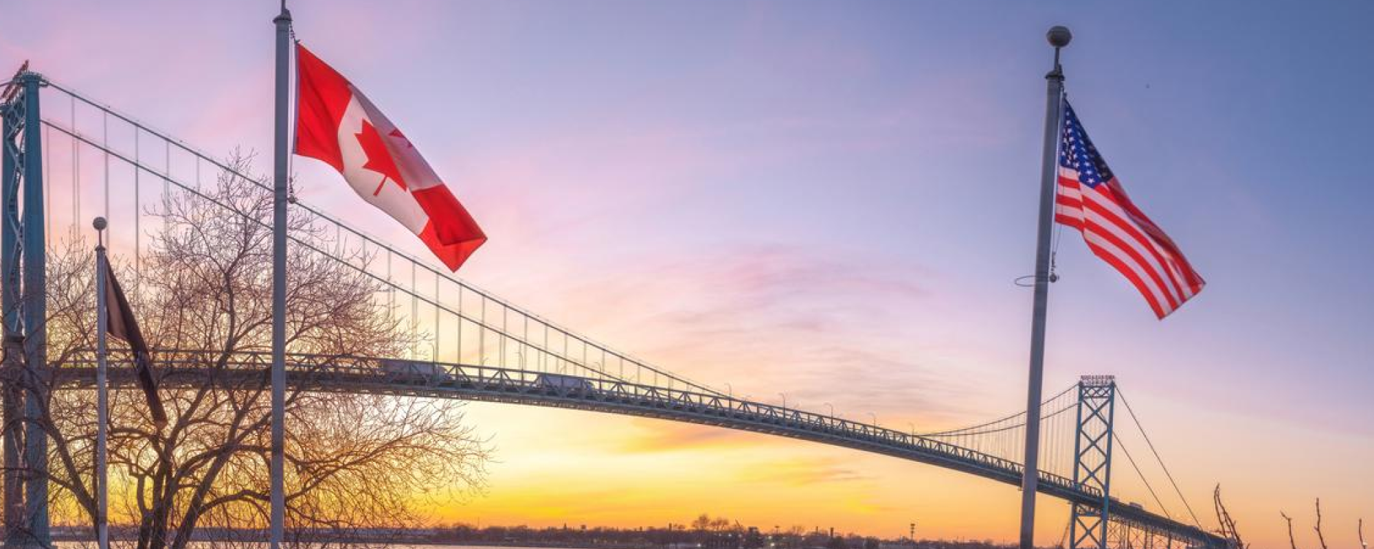 Canadian and American flag vista overlooking bridge.