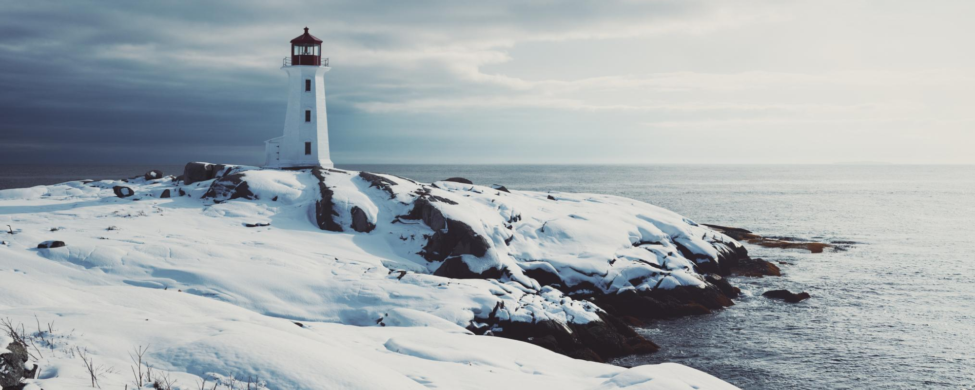 Winter landscape on shore with lighthouse.