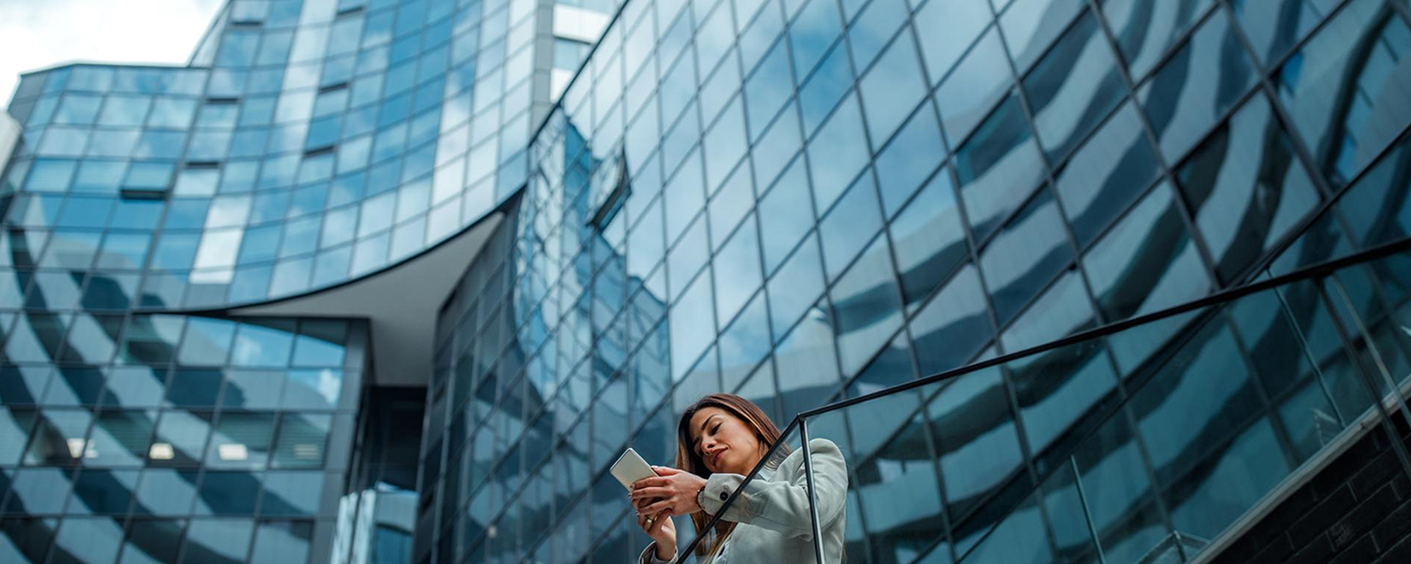 Woman on phone standing in front of office building.