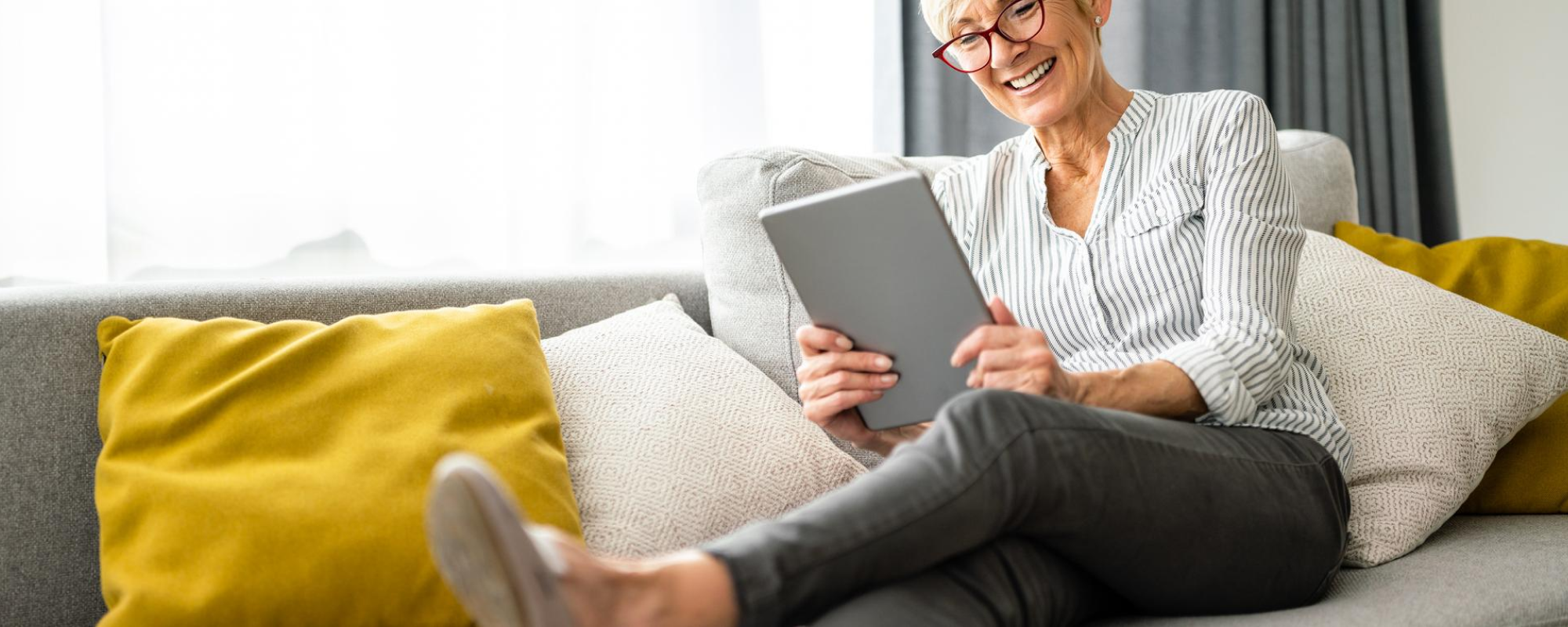 woman reading ipad while lying on couch